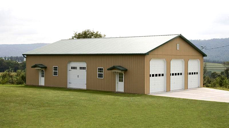 brown building with four garage doors and green roof