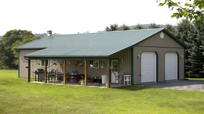 two garage door building with porch in mid-brown and green trim