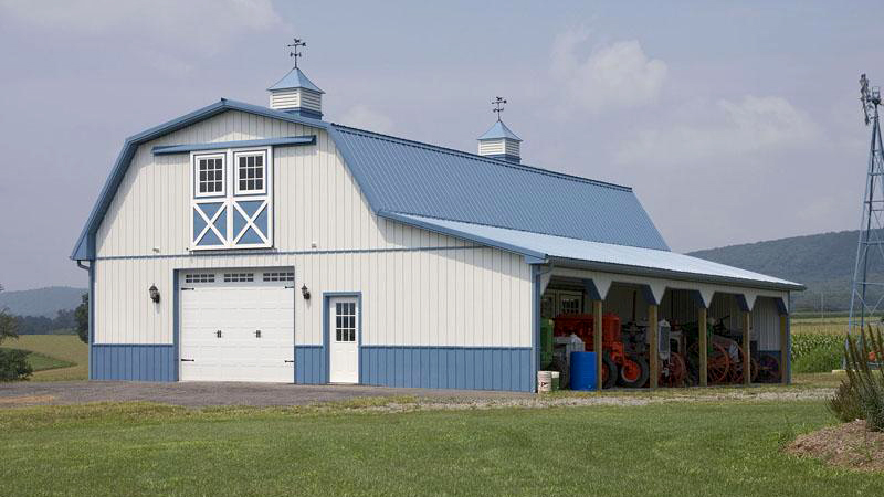 barn style building with single garage door and porch area in white and blue