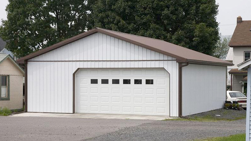 single wide overhead door with a brown roof and trim white building