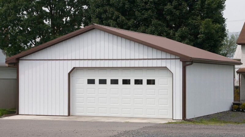 30x32 white residential pole building with 18′ garage door and 9-lite entry