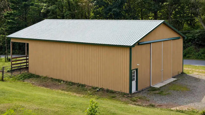 40x60 agricultural pole building with tan siding evergreen roof split sliding door and open gable end