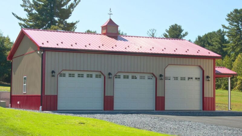 30x40 residential pole building with tan walls scarlett red roof insulated garage doors and decorative cupola with weathervane