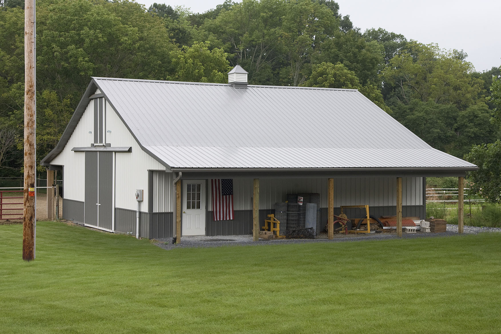 gray and green pole building with tractors