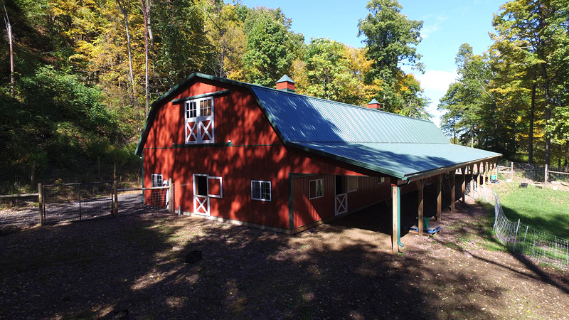 red pole building with white trim and green roof