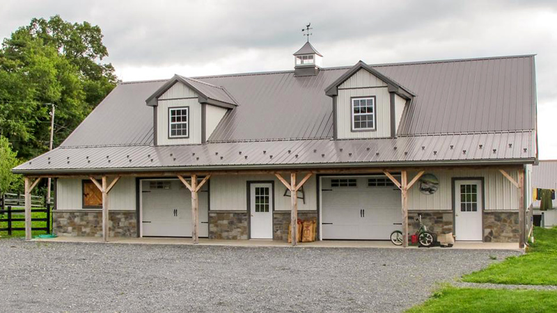 grey roofed barn with white and stone