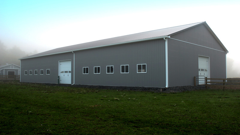 gray building with two garage doors and white trim