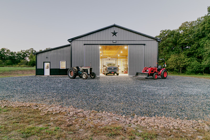 gray and green pole building with tractors