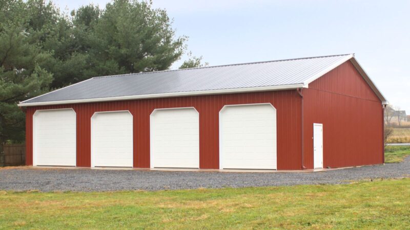 40x60 Red Agricultural Pole Barn with Black Roof, Insulated Garage Doors, and White Trim