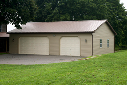 building with large and small overhead door and vinyl siding