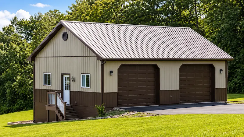 26x38 clay pole barn with bronze roof and trim, 2 large garage doors, sliding windows, attic trusses, wainscoting, and block foundation
