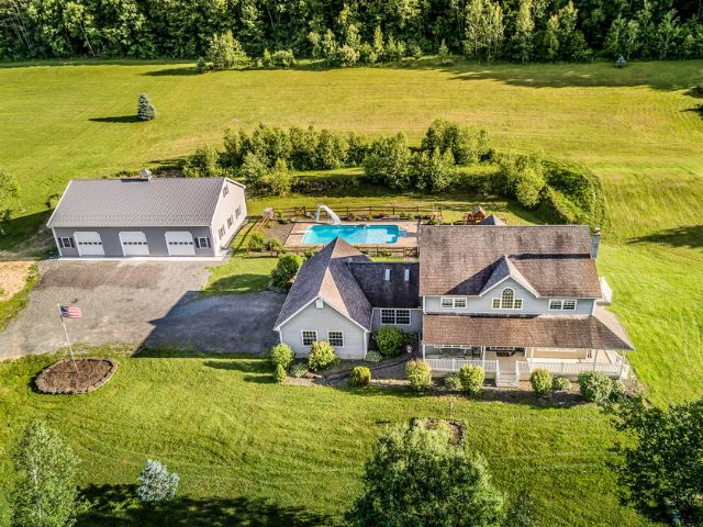 Aerial view of a residential property featuring a Timberline-built pole barn and open landscape