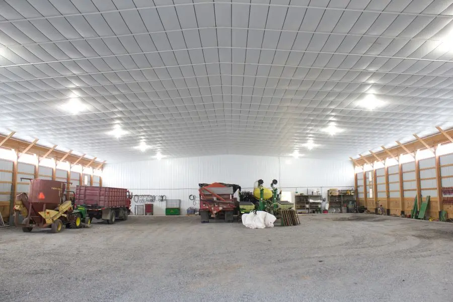 Flexible Interior Layout for Farm Equipment and Workshop Use Clear-span interior of agricultural pole barn with open layout for tractors and workshop space