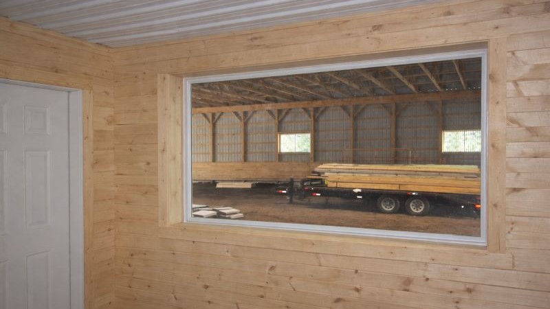 Viewing window from horse barn looking into indoor riding arena
