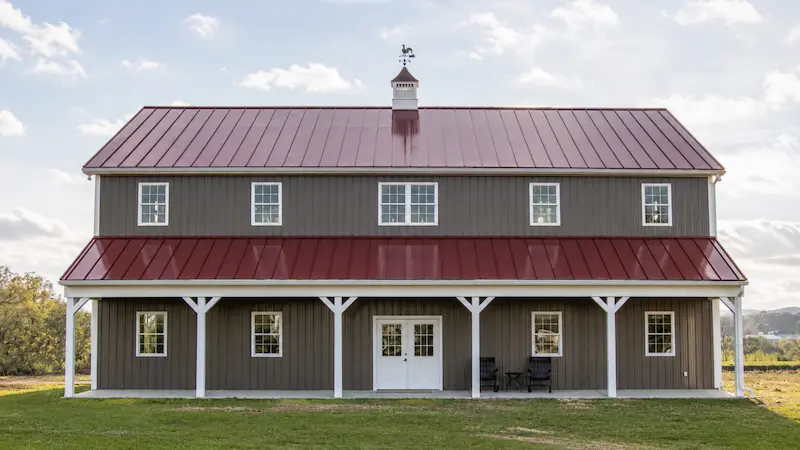 44x60 residential barn building with Charcoal siding, Colonial Red roof, crossbuck sliding barn doors, and covered front porch