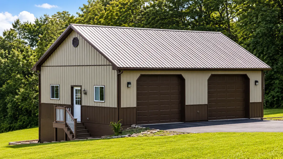 26x38 clay pole barn with bronze roof and trim, 2 large garage doors, sliding windows, attic trusses, wainscoting, and block foundation