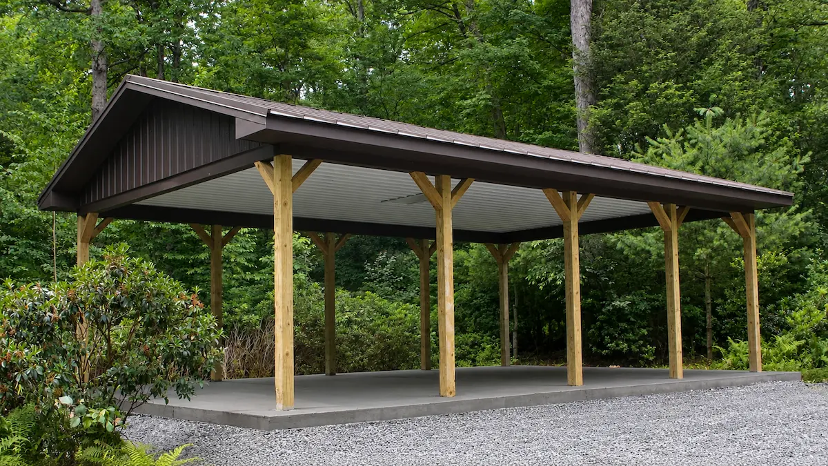 20x32 open pavilion with textured bronze standing seam roof, metal ceiling liner, vented overhangs, and full beam wrap