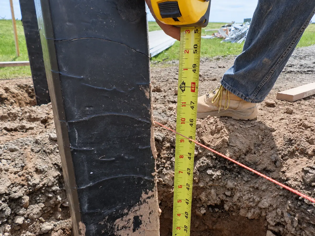 Protected embedded post measured during foundation installation